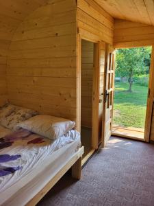 a bedroom in a log cabin with a bed in it at Cristel Căsuța Fără Gânduri in Mesentea