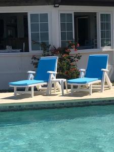 two blue chairs sitting next to a swimming pool at CHILLpill Guest House in Mahébourg