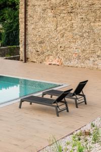 2 sillas y un banco junto a la piscina en Villa Zara Boutique Hotel Resort, en Smolník