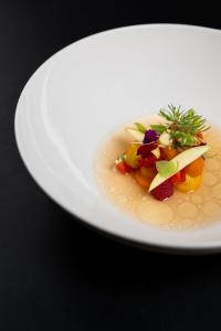 un tazón de sopa con frutas y verduras. en Villa Zara Boutique Hotel Resort, en Smolník