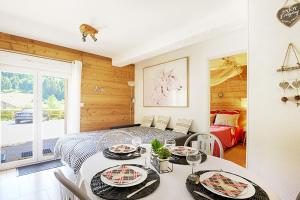 ein Esszimmer mit einem Tisch und einem Bett in der Unterkunft Aux Flocons de la Mauselaine - Station de ski in Gérardmer