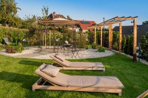 einen Garten mit 2 Liegestühlen und einem Pavillon in der Unterkunft Apart Hotel Wasserturm in Bad Segeberg