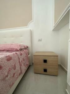 a bedroom with a bed and a wooden nightstand at O’Vascio e maruzzella in Naples