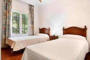 科尼爾－德拉弗龍特拉的住宿－Casa 4，配有2张床的白色墙壁和窗户。