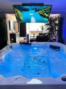 uma grande banheira azul numa sala de estar com televisão em Silver City Apartment em Hamburgo