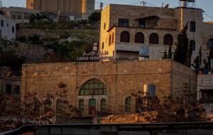 a brick building with a sign on top of it at Lamar Guesthouse - Hebron in Hebron