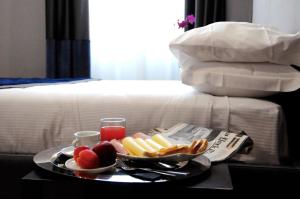 een dienblad met eten op een tafel naast een bed bij Place 24 Suites & Wellness in Rome
