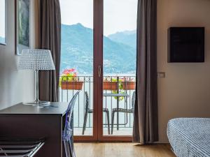 een hotelkamer met uitzicht op een balkon bij Foresteria Lago di Como in Menaggio