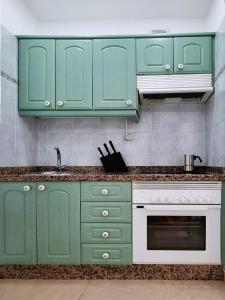 a kitchen with green cabinets and a sink at Paraiso Studio in Playa Paraiso