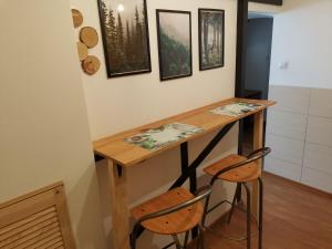 eine kleine Küche mit einem Holztisch und zwei Hockern in der Unterkunft Przystanek Srebrna Góra in Srebrna Góra