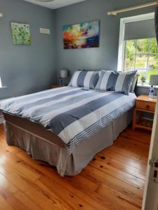 a large bed in a bedroom with a wooden floor at Butterhouse in Trim