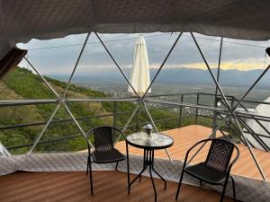 two chairs and a table in a room with a view at Signagi Glamping in Sighnaghi