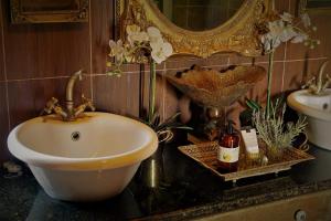 een badkamer met een wastafel en een spiegel bij Bygracealone Manor in Outeniekwa