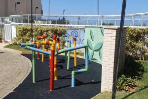 um parque infantil com equipamento de brincar colorido num parque em Resort Itanhaém - Pé na areia em Itanhaém