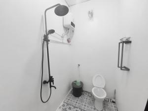 y baño blanco con ducha y aseo. en Baronda Guest House, en Sorong