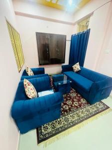 uma sala de estar com um sofá azul e uma televisão em apartment by Xoyo em Varanasi