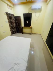 een kamer met een bed en een televisie. bij apartment by Xoyo in Varanasi