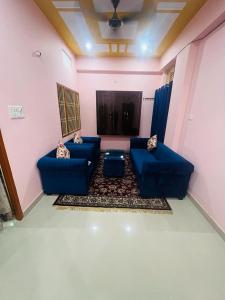 een woonkamer met twee blauwe banken in een kamer bij apartment by Xoyo in Varanasi
