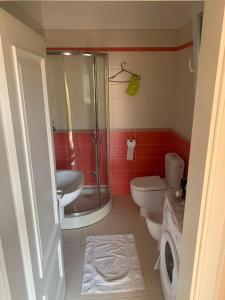 een badkamer met een douche, een toilet en een wastafel bij Apartment with garden in the center of Durres in Durrës