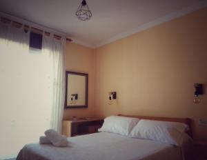 1 dormitorio con 2 camas y ventana en Hostal Pensión Mar de Plata, en Lugo