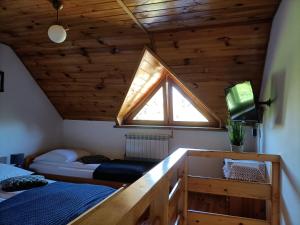 a attic bedroom with two beds and a window at Mala Chatka in Wetlina