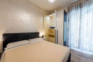 a bedroom with a large bed and a window at APARTMENT BONCIARI PERUGIA Comodo e moderno bilocale con posto auto gratuito e self check in in Perugia