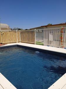 a swimming pool in front of a wooden fence at וילת הנחלה למשפחות Nahala Villa in Shadmot Devora