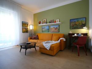 sala de estar con sofá naranja y mesa en Il mare in Piazza, en Albisola Superiore