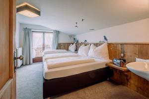 1 Schlafzimmer mit 2 Betten und einem Waschbecken in der Unterkunft Alpengasthof Hochsöll in Söll