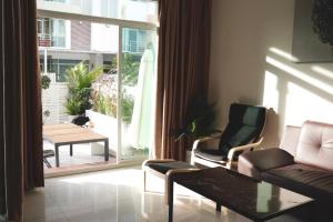 uma sala de estar com um sofá e cadeiras e uma grande janela em Kann Villa Jomtien Beach & Yahaha em Praia de Jomtien
