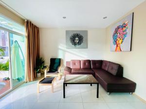 uma sala de estar com um sofá e uma mesa em Kann Villa Jomtien Beach & Yahaha em Praia de Jomtien