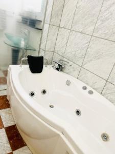 eine weiße Badewanne im Bad in der Unterkunft Susukino Tower Apartment アムスタワー in Sapporo