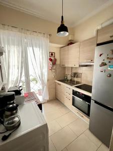 a kitchen with a white refrigerator and a window at Irene's cozy apartment in Volos