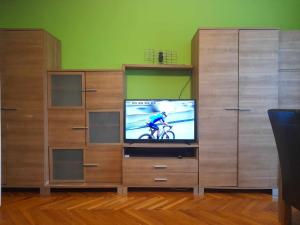 a wooden entertainment center with a tv and a tv screen at Mieszkanie Warszawska 5 in Giżycko
