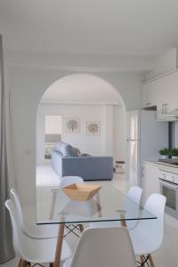 cocina y sala de estar con mesa de cristal y sillas en Chalet Marpacos en Santa Cruz de Tenerife