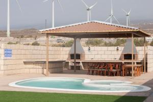 uma piscina com um pavilhão, uma mesa e cadeiras em Chalet Marpacos em Santa Cruz de Tenerife
