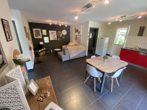 een woonkamer met een tafel en een slaapkamer bij Villa Sylva in Sarlat-la-Canéda