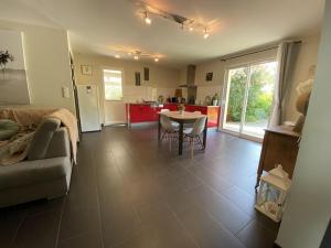een woonkamer met een bank en een tafel en een keuken bij Villa Sylva in Sarlat-la-Canéda