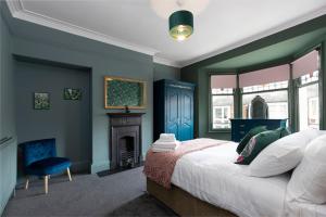 a bedroom with blue walls and a bed and a fireplace at Big House, and a lot to give! in Middlesbrough