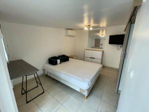 a small bedroom with a bed and a table at Maison de vacances familiale in Ouistreham