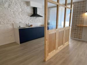 a kitchen with blue cabinets and a large glass door at Mamavira Hospedaje in Meaño