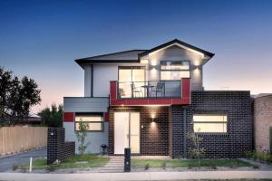 a brick house with a balcony on a street at Home from Home Cozy Beauty Park Front in Melbourne