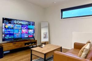 a living room with a large flat screen tv at Home from Home Cozy Beauty Park Front in Melbourne