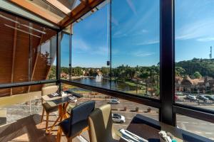 a room with large windows and a view of a river at Hotel Laghetto Gramado in Gramado