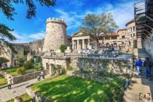 a castle with a green lawn in front of a building at Le Liv On in Rijeka