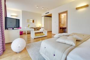 a white bedroom with a large bed and a living room at Best Western Plus Leone di Messapia Hotel & Conference in Lecce