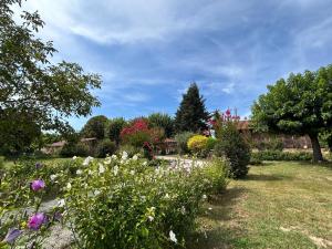 un jardín con flores y árboles en un patio en Gîte La Bergerie, en Le Buisson de Cadouin