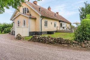 a house with a stone wall in front of it at Stubbegården - Unique swedish style in Vadstena