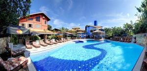uma grande piscina com cadeiras e um edifício em Salvetti Praia Hotel em Boraceia