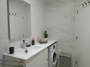 a white bathroom with a sink and a washing machine at Bungalow Paseo del Mar- PLAYA ROCA Residence sea front access - Free AC - Wifi in Costa Teguise